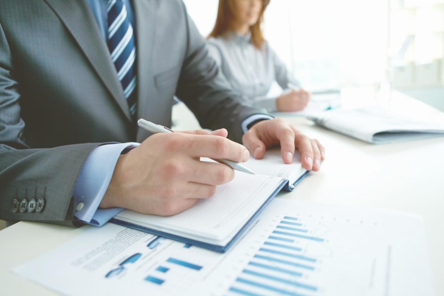 Financial analysts reviewing market data and charts on multiple screens